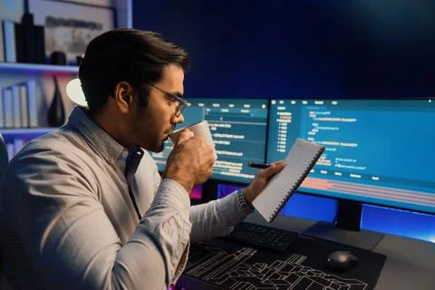 IT working with drinking coffee coding on pc screen, reading note. Surmise. Stock Photos