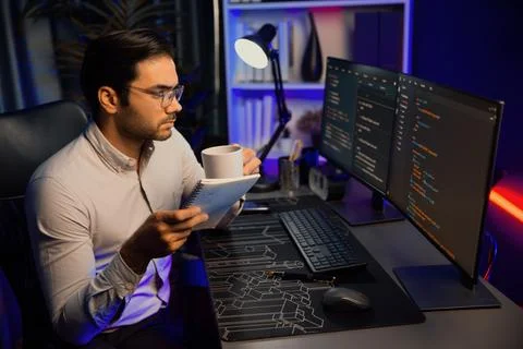 IT working with drinking coffee coding on pc screen, reading note. Surmise. Stockfoto's