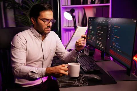 IT working with drinking coffee coding on pc screen, reading note. Surmise. Stockfoto's