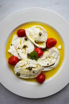 Italian caprese salad with sliced tomatoes, mozzarella, basil, olive oil, pepper Stock Photos