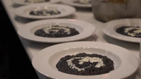Italian chef makes squid ink risotto Stock Footage 228293380