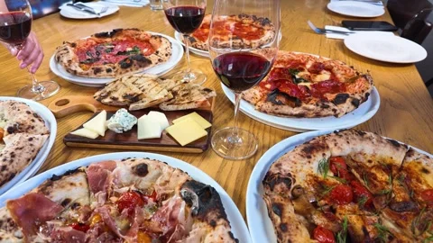 Italian Dinner Table with Neapolitan Pizzas and Red Wine Stock Footage 339119250