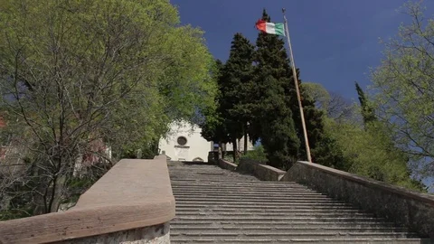 Italian flag and staircase to Santa Augusta Sanctuary above Vittorio Veneto Stock Footage 77751153