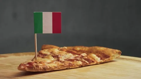 Italian flag stuck into edge of classic cheese pizza slice, symbol of authentic Stock Footage 323458424