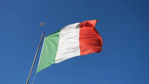 Italian Flag waving in the wind before a deep blue sky Stock Footage 119364981