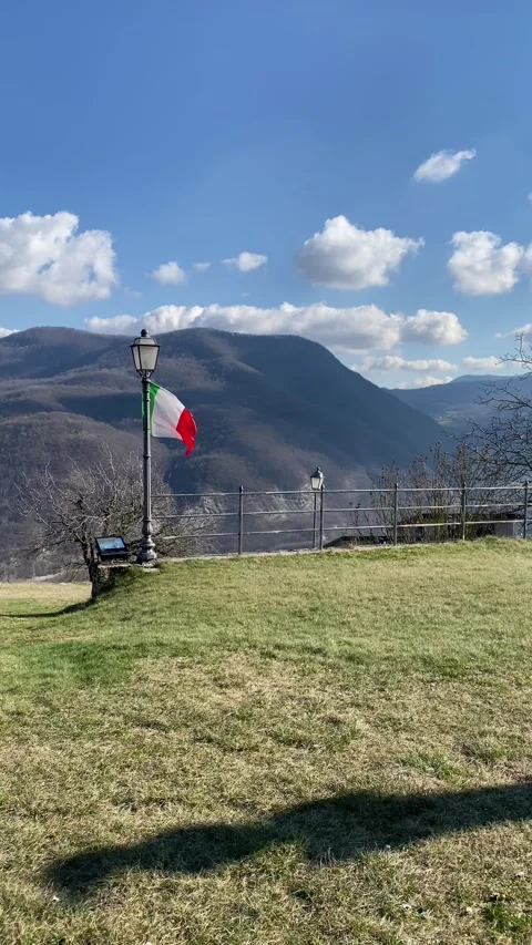 Italian flag waving in the wind at Monastero Val d’Arda viewpoint Stock Footage 306848068