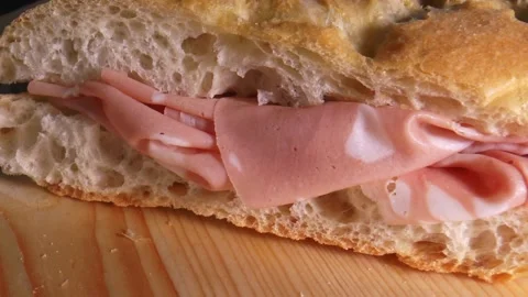 Italian focaccia bread sandwich filled with bologna pink mortadella, pan Stock Footage