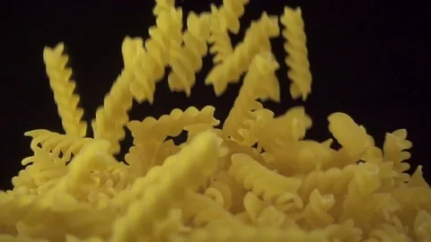 Italian fusilli falling. Spirelli pasta on dark background. Slow motion shot Video stock 72246053
