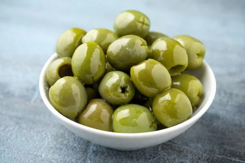 Italian green olives in white bowl. healthy food Stock Photos