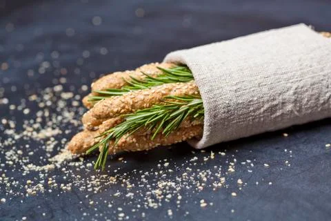 Italian grissini or salted bread sticks with rosemary herb on linen napkin on Stock Photos