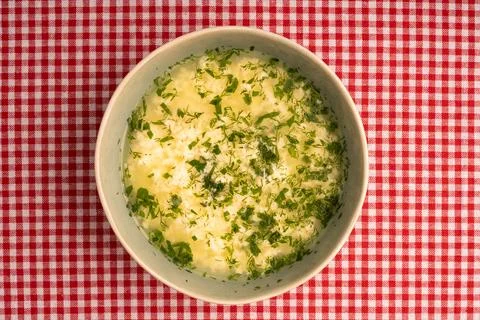 Italian stracciatella egg drop soup with parsley in bowl on tablecloth backgr Stock Photos