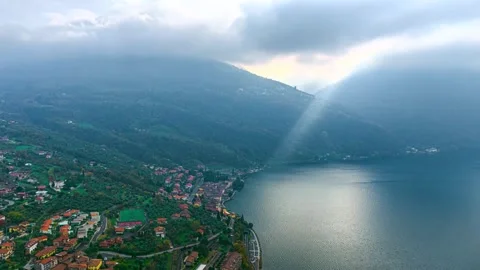 Italian town beside a blue lake beneath misty mountains Stock-Footage 341328341