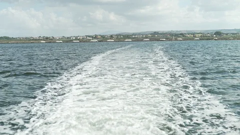Italy 015 Waves Trailing Behind Small Boat Near Trapani Salt Flats Stock Footage 129480304