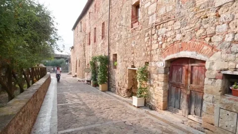 Italy - 03 20 2025: Rustic Stone Building with Weathered Wooden Door and Potted Stock Footage 324490308