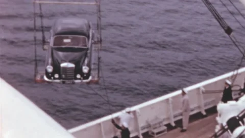 Italy - 1965: Crew members pull the ropes to load a car on the hold of the ship Stock Footage 200473694