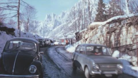 Italy - 1970: Cars wait in queue on a two way snow covered street during winters Stock Footage 204064794