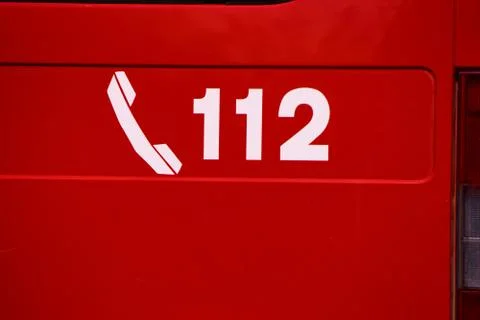 Italy - July 27, 2019: Close up of the 112 phone number written on a firetruck. Stock Photos