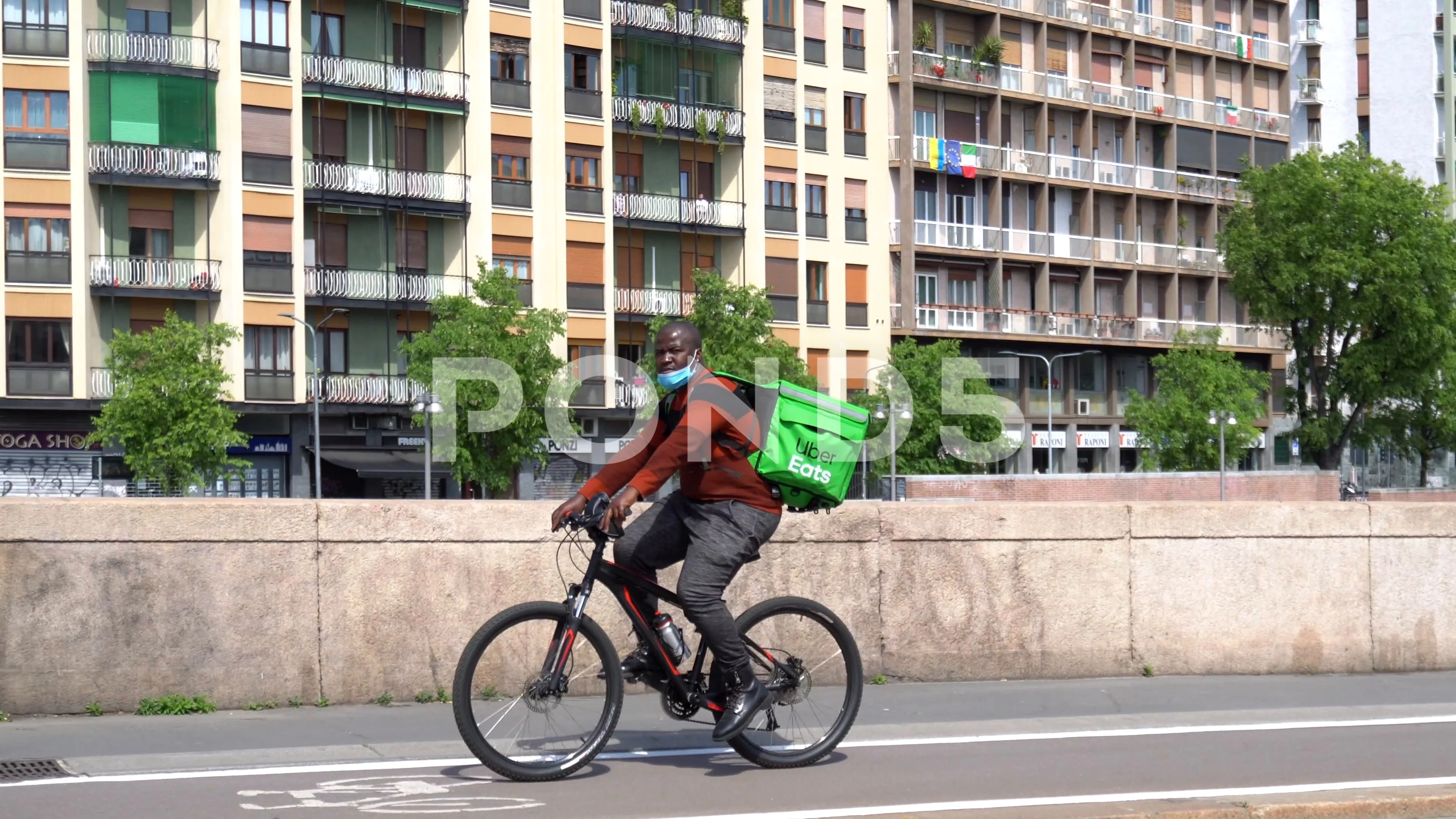 Italy , Milan April 25,2020 - Uber eats delivery food - bike driver going  in a s