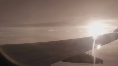 Italy package 7 | Sun shining through clouds next to airplane wing Stock Footage 115969045