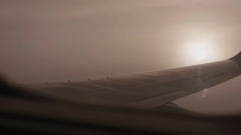 Italy package 8 | Sun light rays shining through clouds next to airplane wing Stock Footage 115970095