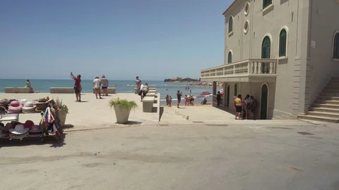 Italy, Punta Secca, Sicily, : Punta Secca main square, Tourist take photo Stock Footage 91942385