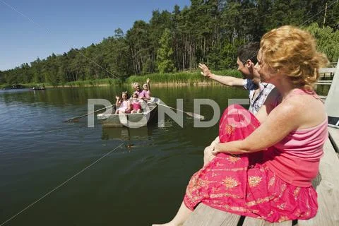 Italy, South Tyrol, Grandparents and grandchildren in rowing boat, parents Stock Photos