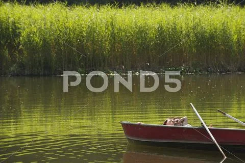 Italy, South Tyrol, Young couple lying in rowing boat Stock Photos