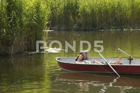 Italy, South Tyrol, Young couple lying in rowing boat Stock Photos