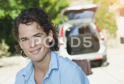 Italy, Tuscany, Close up of young man and car with luggage in background Stock Photos