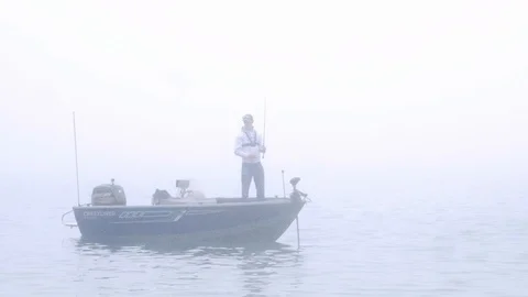 ITASCA CO, MN - 4 AUG 2019: Fisherman in boat is fishing on a foggy morning. Stock Footage 122548773