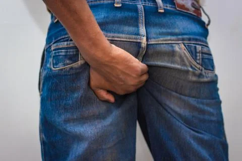 Itching - butt rashes. Man Rude scratches his buttocks indoor - NOT something Stock Photos