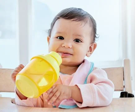 Itchy gums and soft chews. a sweet baby girl drinking a bottle at home. Stock Photos