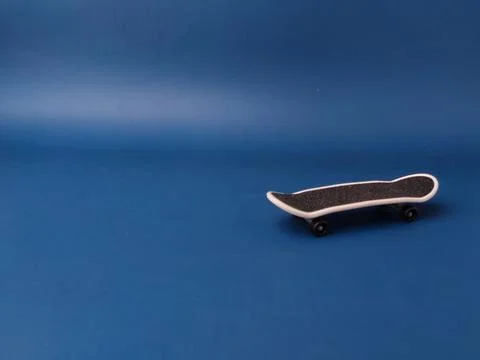 This item is a finger skateboard on a blue background Stock Photos