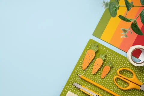 Items for paper art hobby: scissors, pencil, eraser, cutting mat on blue back Stock Photos