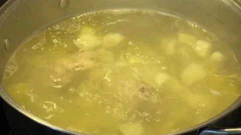 Ithe pot is preparing soup always boils water and floats potatoes Stock Footage 241465216