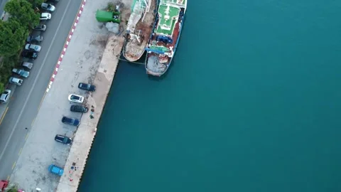 Itle 1: Aerial top down view of coastal port with fishing boats and parking Stock Footage 337462870
