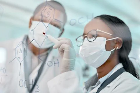 Its all starting to add up. two scientists drawing molecular structures on a Stock Photos