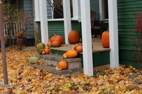Its fall time and close to halloween, a front porch decorated with pumpkins s Stock Photos