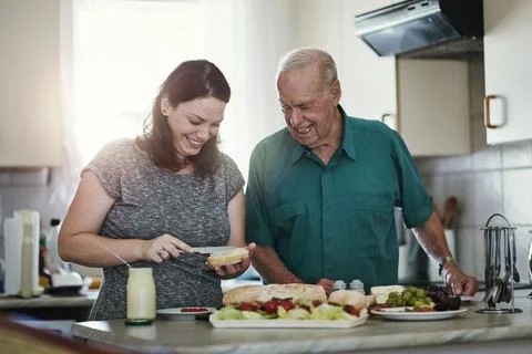 Its an honor to care for aging parents. a woman making her senior parent a Stock Photos