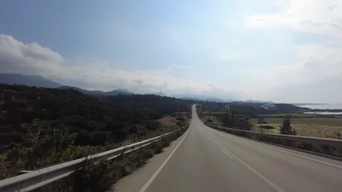 It's a long, endless road with mountains on one side and sea on the other. Stock Footage 278111347
