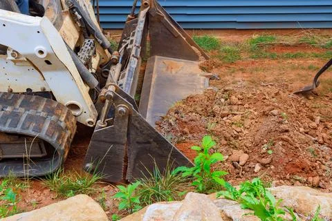 With its mini bulldozer effectively tackle landscaping project, manipulating Stock Photos