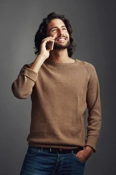 Its Mr Handsome calling...Studio shot of a handsome young man using a mobile Stock Photos