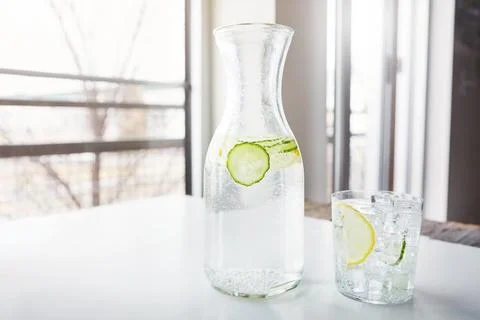 Its the number one nutrient that your body needs. a jug and glass of water with Stock Photos