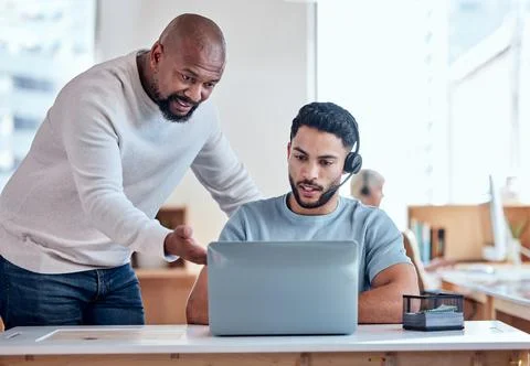 Its quite a simple process. Shot of a businessman teaching his staff member i Stock Photos