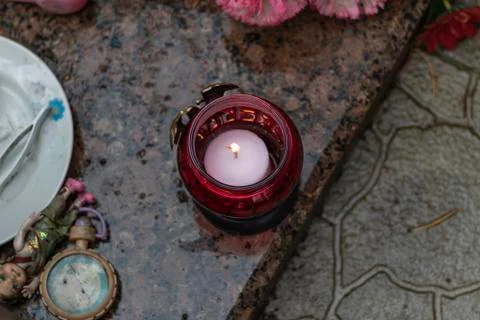 It's raining. the candle is burning. background grave. marble slab. Stock Photos