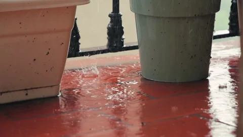 Its raining heavily on the open balcony of a building, raindrops are scattering Stock Footage 326484221