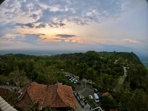 Its rooftop and surrounding trees highlighted by wispy clouds.  Stock Photos