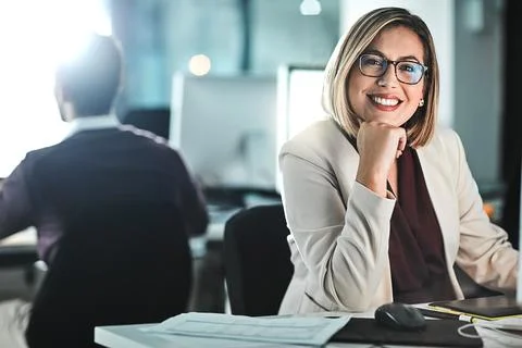 Its satisfying proving the naysayers wrong. a businesswoman sitting at her desk. Stock Photos