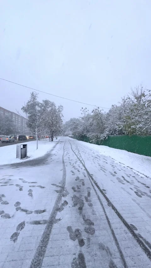 It's snowing outside. Snow-covered street in city with cars, winter cityscape Stock Footage 288100916
