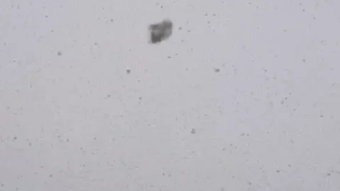 It's snowing. snow falls on camera. Snow against a cloudy sky. Stock Footage 194288702